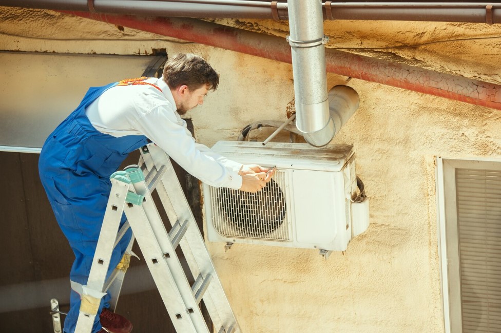 Técnico instalando un aire acondicionado split con medidas de seguridad