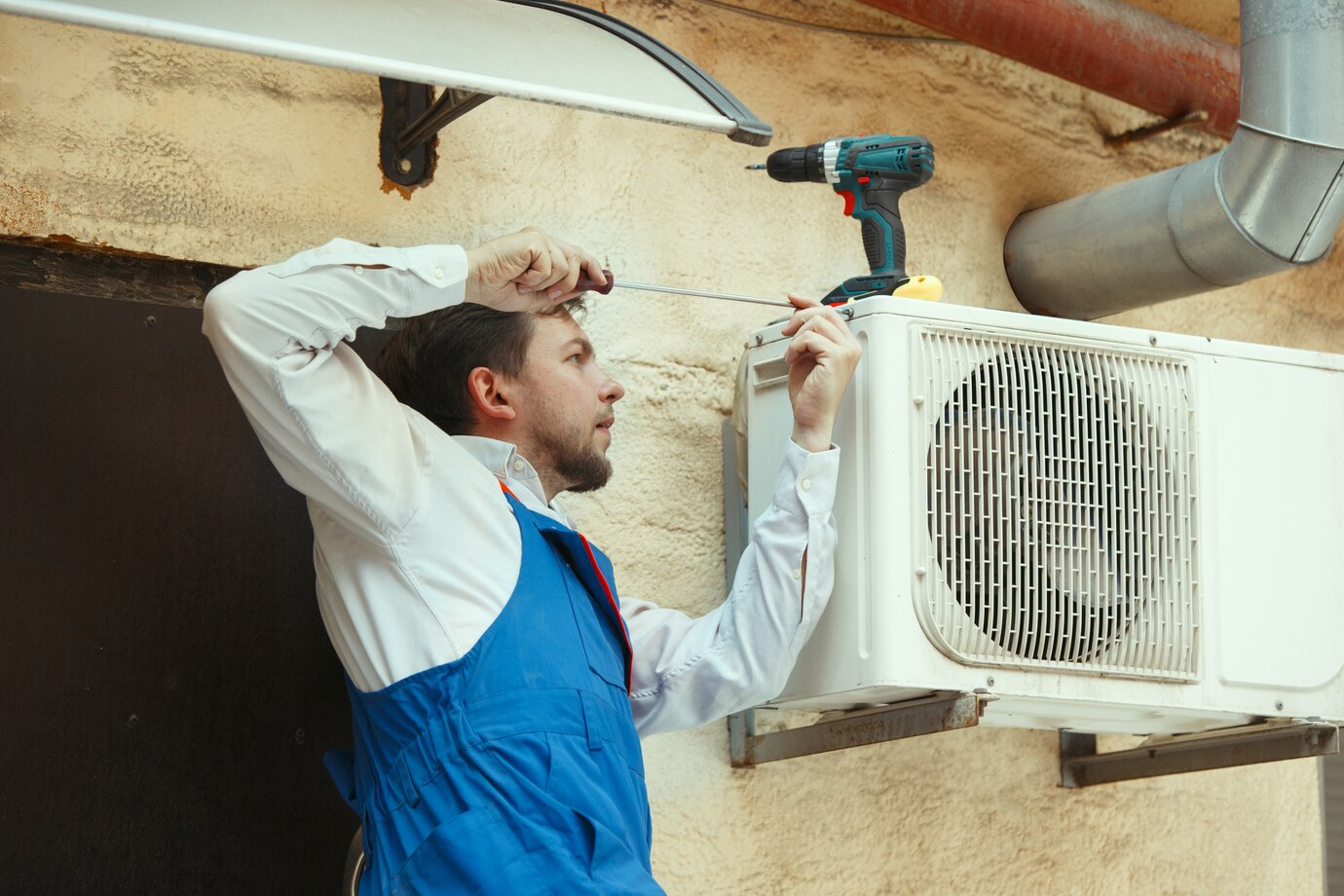 Instalador colocando la unidad exterior de un aire acondicionado en vivienda de Benidorm
